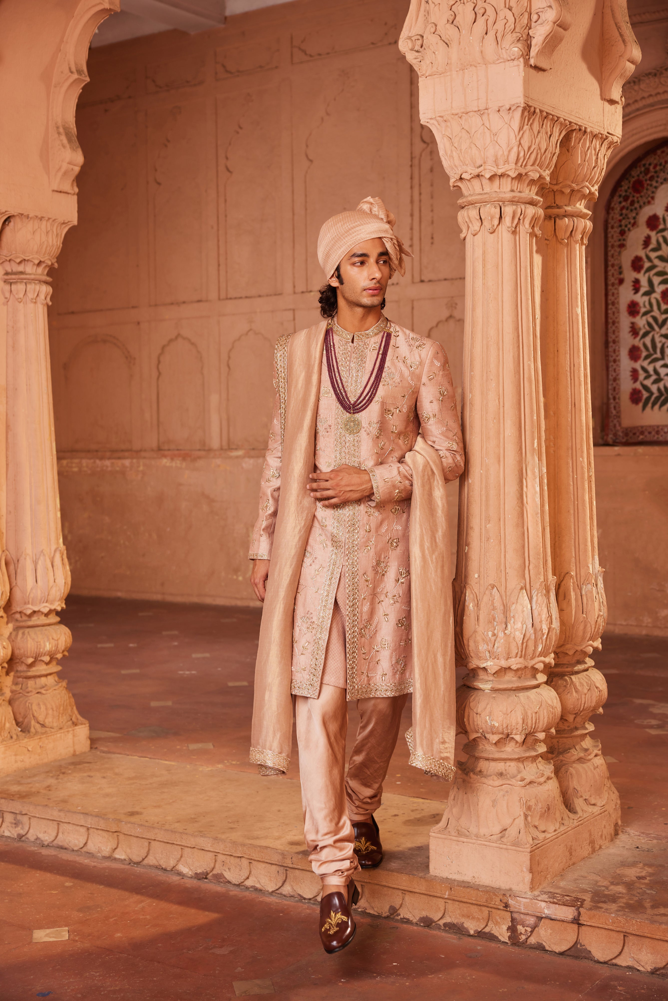 Close-up of sherwani displaying fine zardozi, resham, dabka, and thread embroidery with floral motifs and a detailed center border, complemented by a kurta, pants, and a matching embroidered stole.