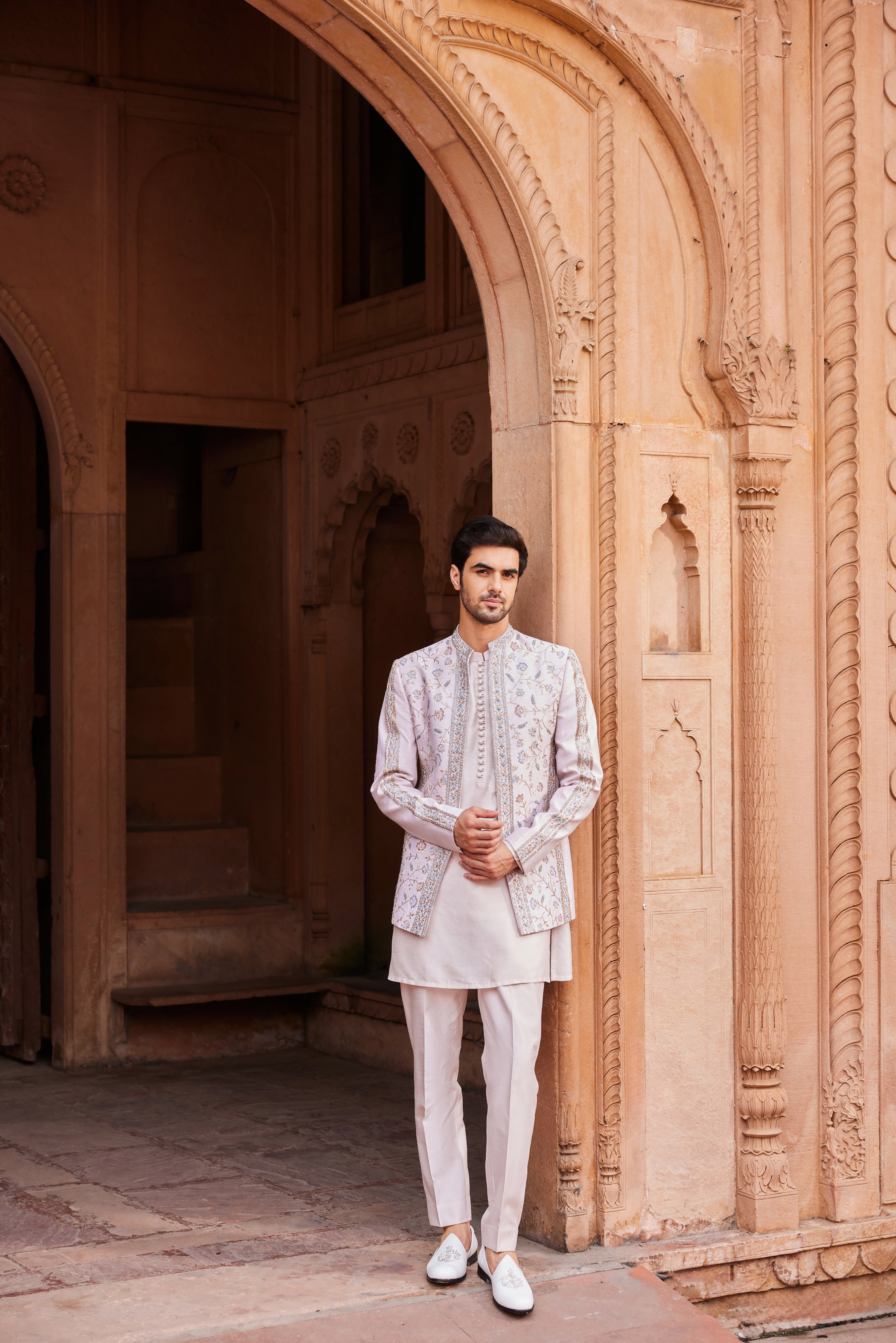 A jacket intricately adorned with a fine mix of colorful resham, thread, zardozi, and dabka work, featuring all-over floral motifs. It is paired with a detailed kurta and pants for a refined and elegant look.