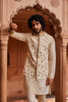  A Nehru jacket featuring delicate floral designs with intricate zardozi, dabka, and zari handwork, paired with a monotone kurta and pants for a refined, cohesive look.

