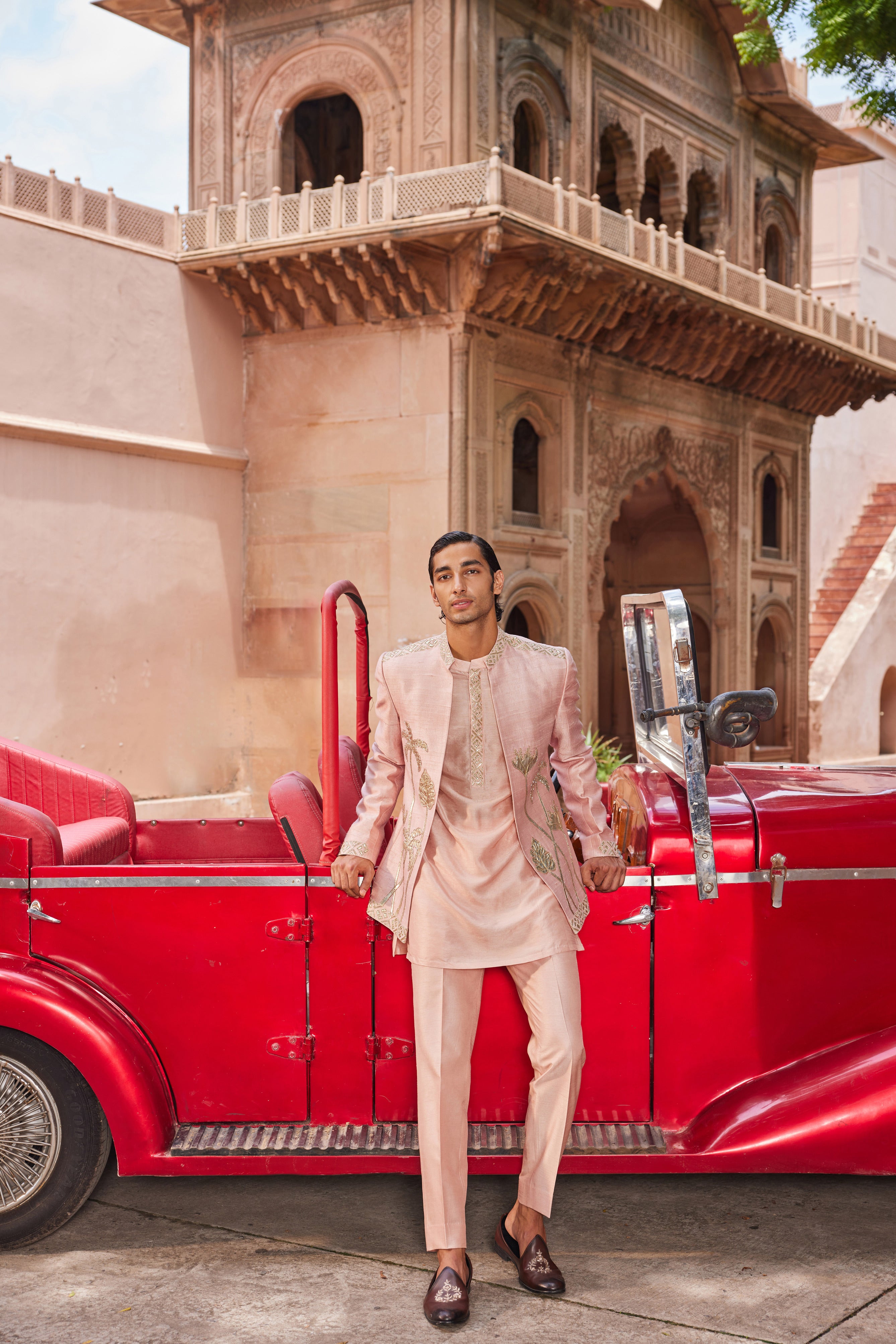 A jacket embellished with leather patch palm tree and floral motifs, along with a striking geometric border, paired with a detailed kurta placket and tailored pants for a unique and stylish ensemble.