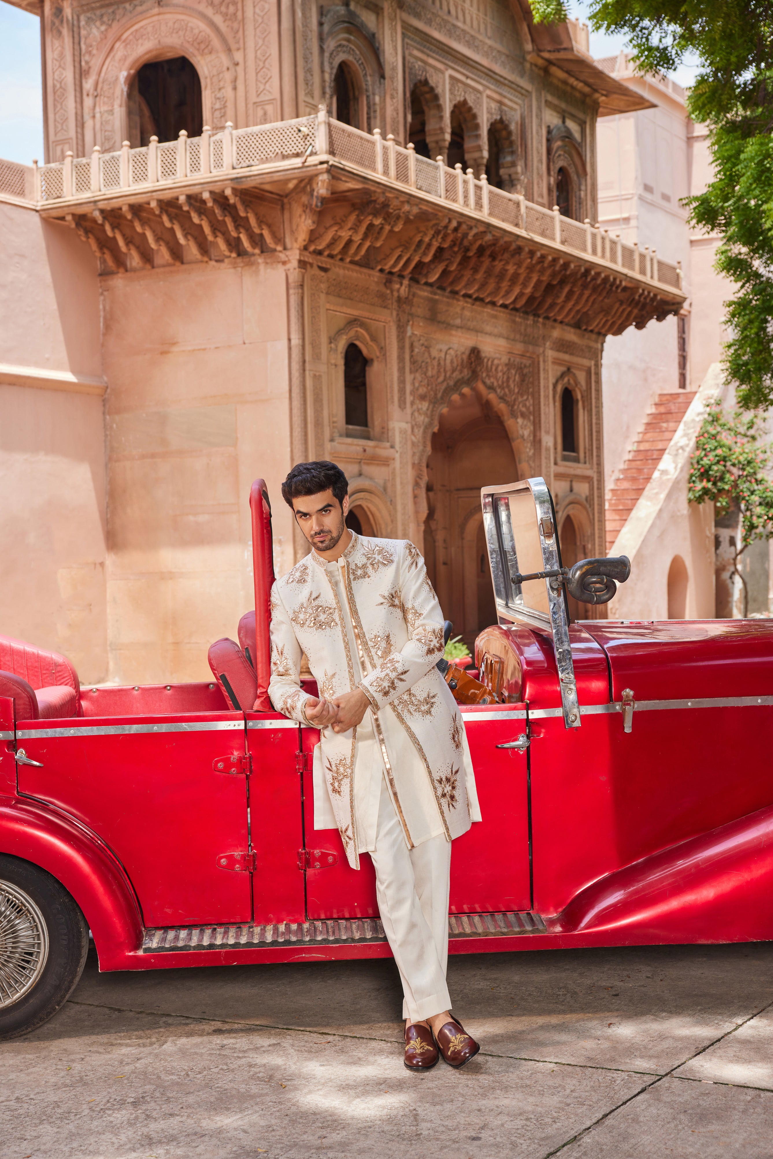 A lavish sherwani adorned with leather patch applique work, featuring intricately embellished floral butta motifs and a detailed placket, paired with a monotone kurta and matching pants for a bold and refined look.
Close-up of a sherwani showcasi