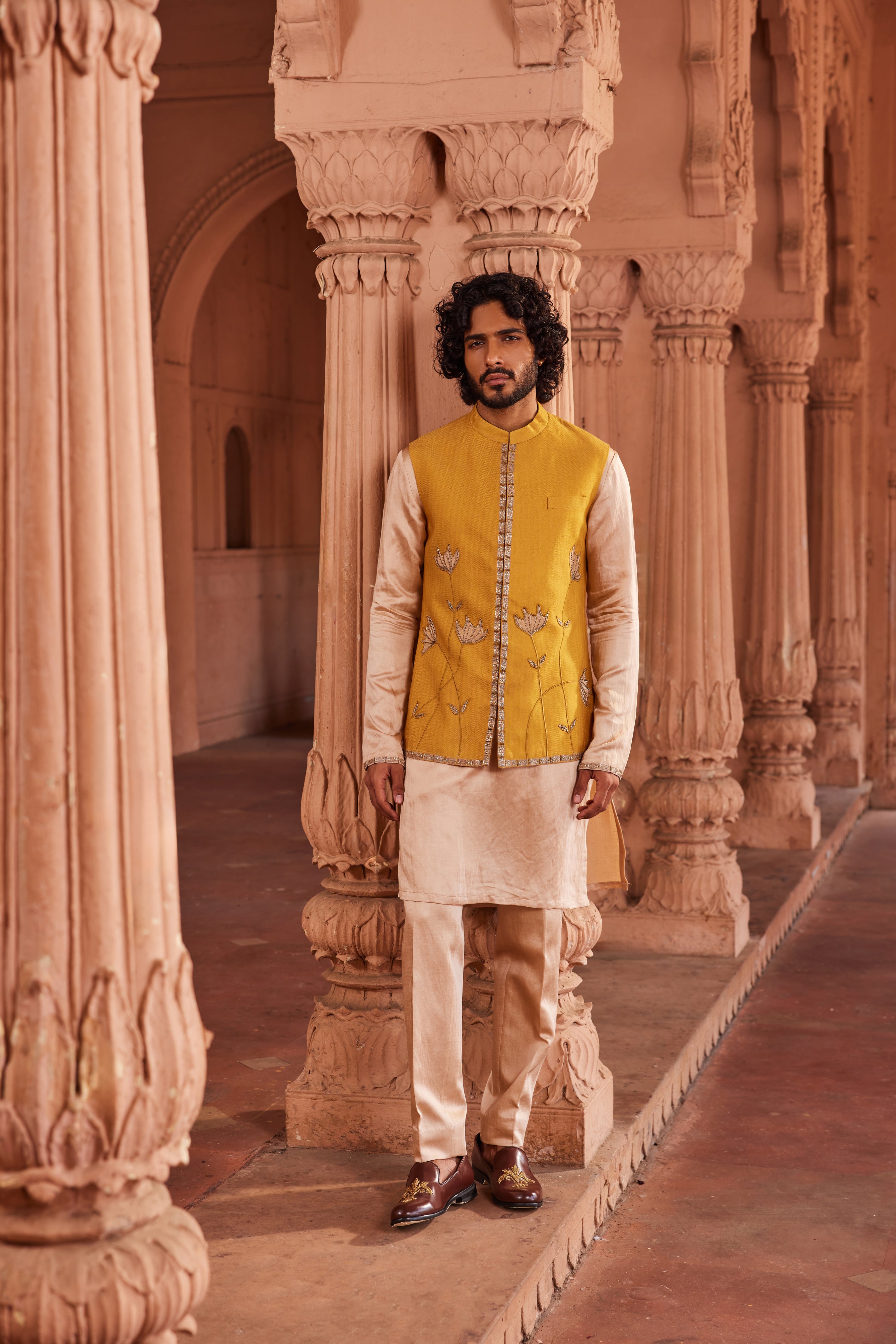 A Marigold Nehru Jacket Set featuring a jacket with delicate hand-embellished tissue applique work, paired with a contrasting beige kurta and pants with intricate detailing