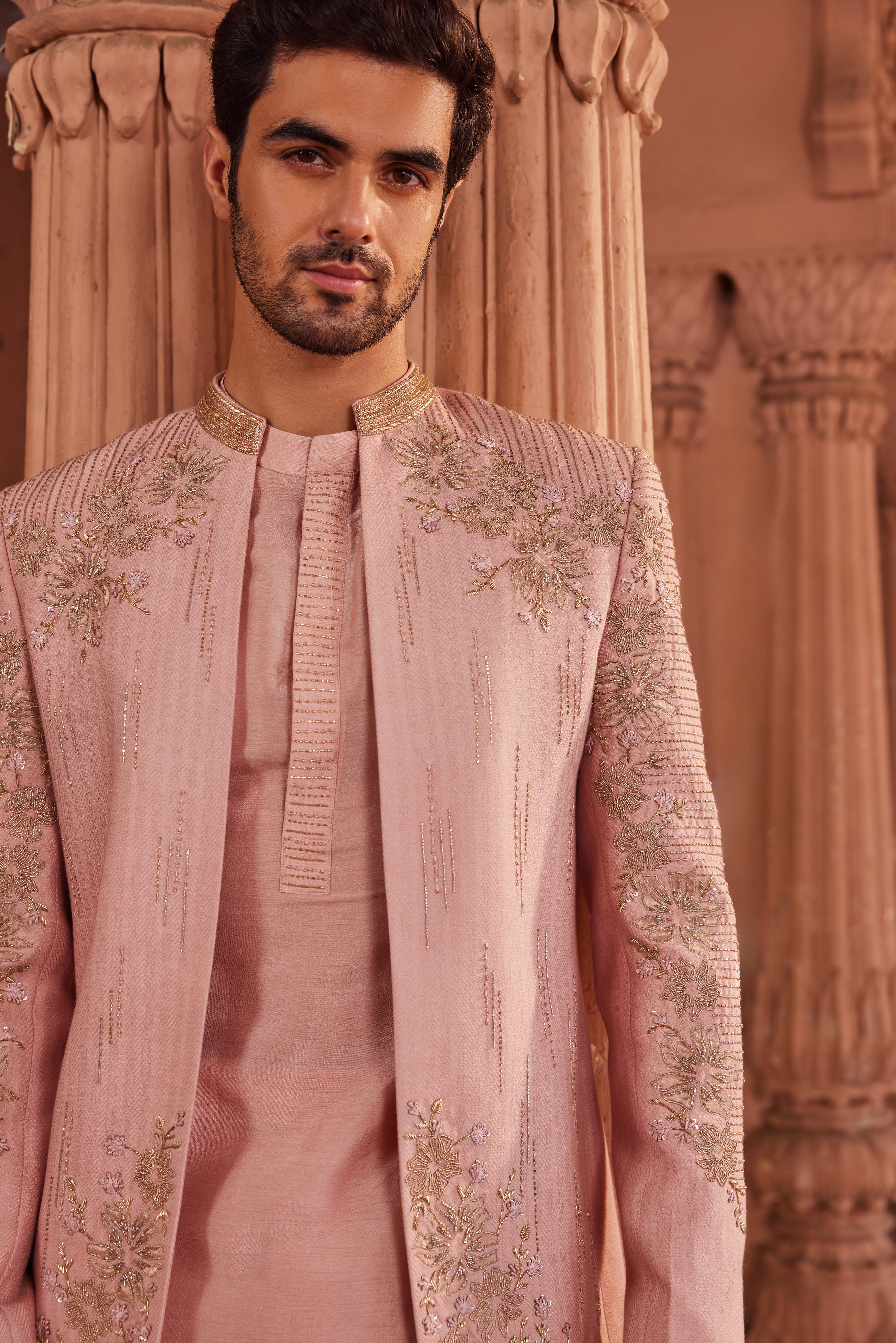 Close-up of a jacket adorned with tonal floral and line embroidery, highlighted by intricate tissue applique detailing, complemented by a detailed kurta placket and tailored pants.