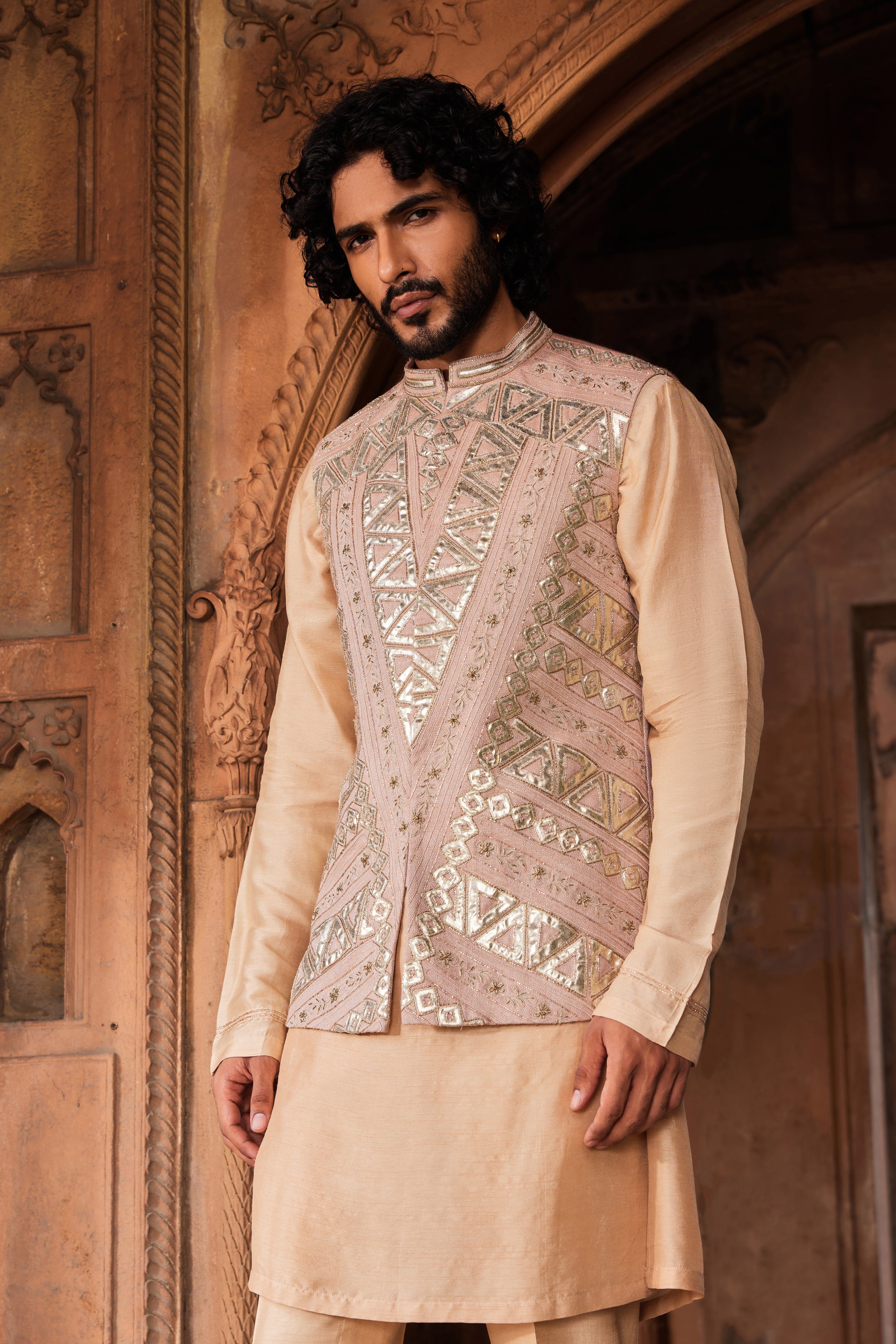 A stylish Ibaadat Nehru Jacket Set, showcasing a geometric jacket adorned with leather patches, kiran dori, and hand-embellished resham and dabka work, complemented by a detailed kurta and pants