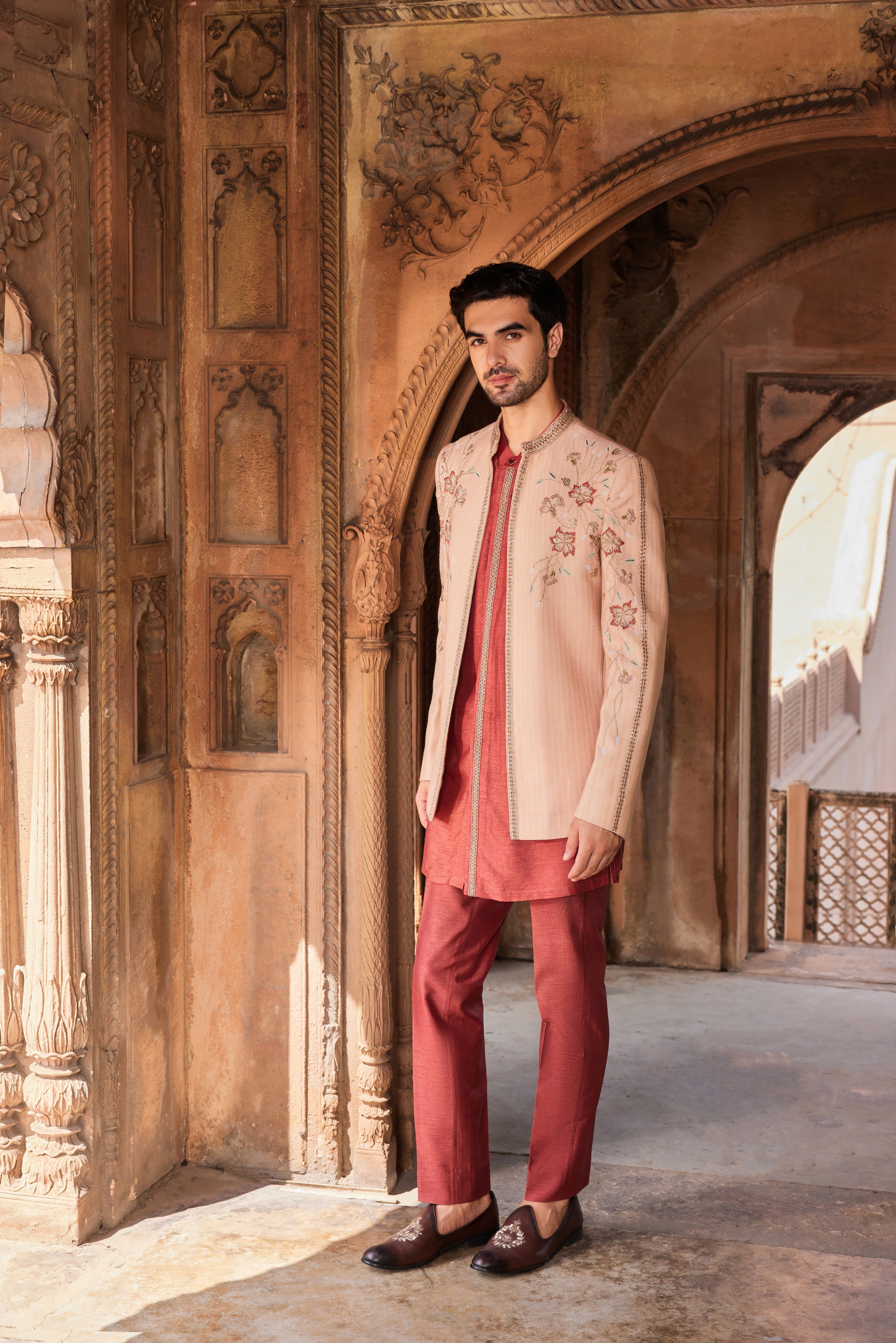 Close-up of a jacket showcasing finely detailed floral embroidery accented with cutdana, dabka, and zardozi, complemented by a contrasting kurta and pants.