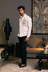 A cotton satin shirt in ivory, featuring a striking embroidered dragon and zipper accents.