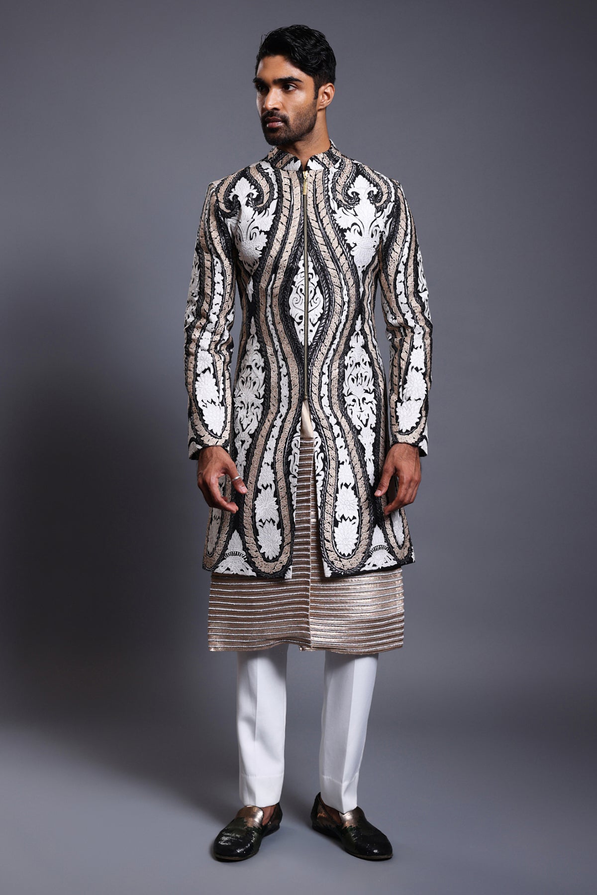 Close-up of black silk sherwani featuring detailed applique in ivory, gold, and gunmetal, enhanced with crystal rope work