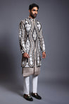 Elegant black and ivory sherwani with applique and stripwork design, accented by sparkling crystal rope details.