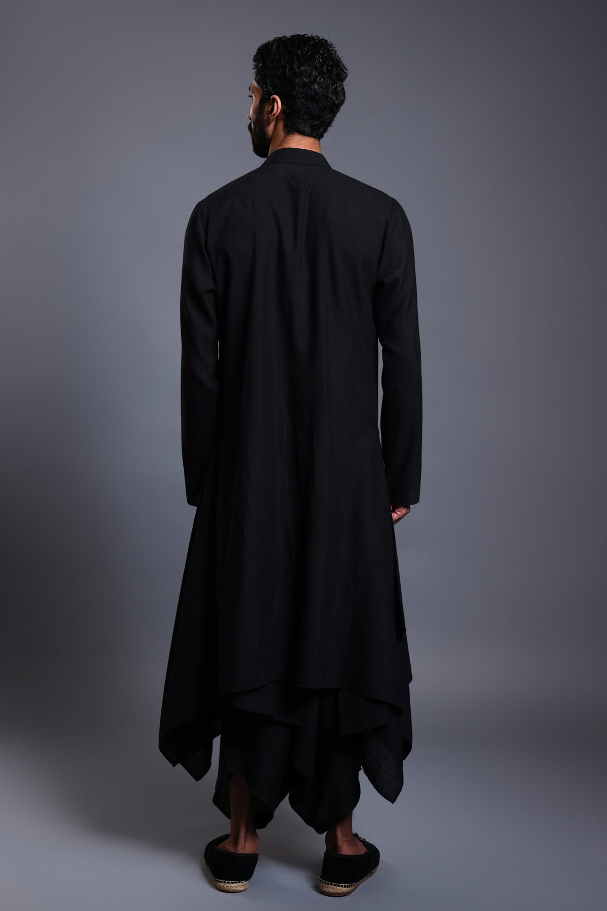 Sophisticated black linen draped kurta featuring emerald stripwork and a crystal rope yoke, paired with draped dhoti pants.