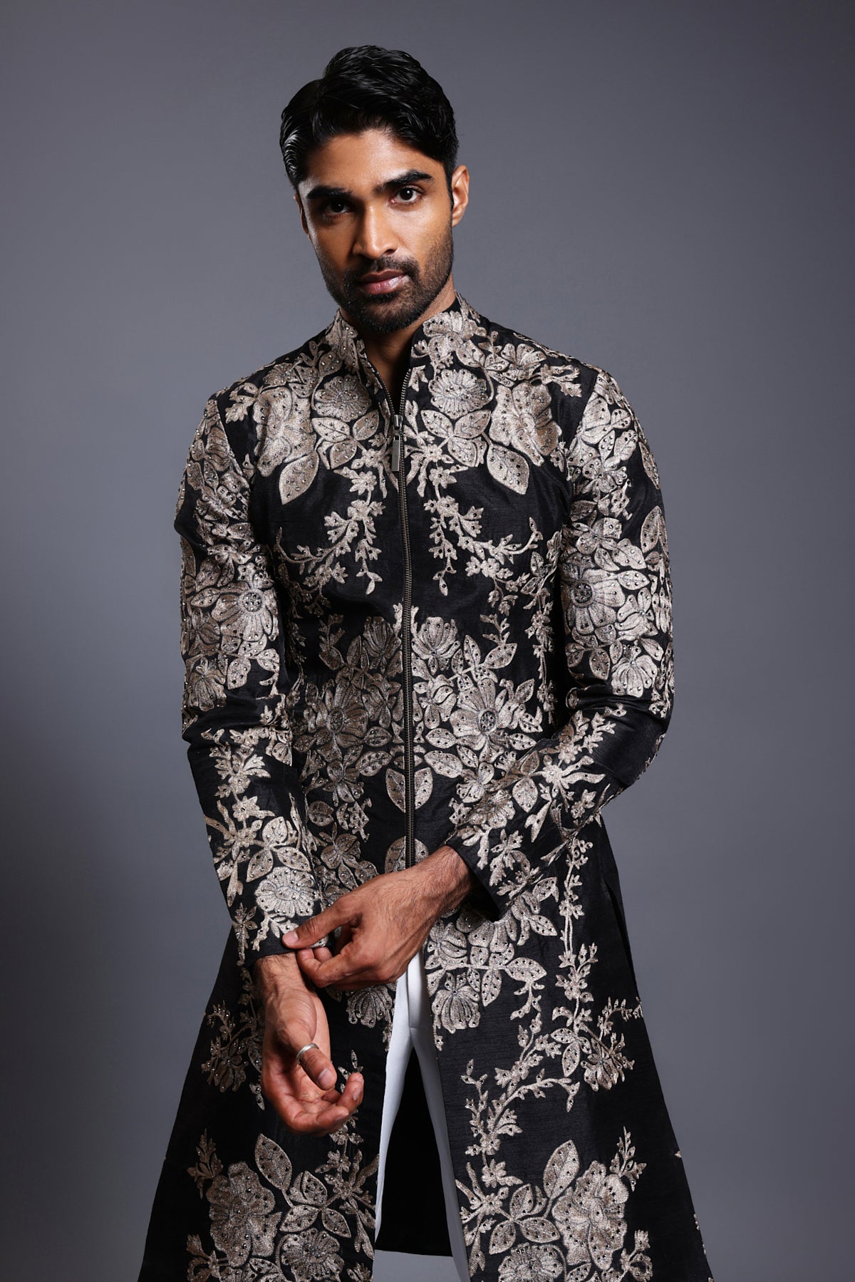 Elegant black silk sherwani with gold and silver zari embroidery, enhanced by subtle crystal details.