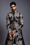 Elegant black silk sherwani with intricate zari embroidery and sparkling crystal accents, exuding timeless sophistication.