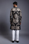 Elegant black silk sherwani with gold and silver zari embroidery, enhanced by subtle crystal details.