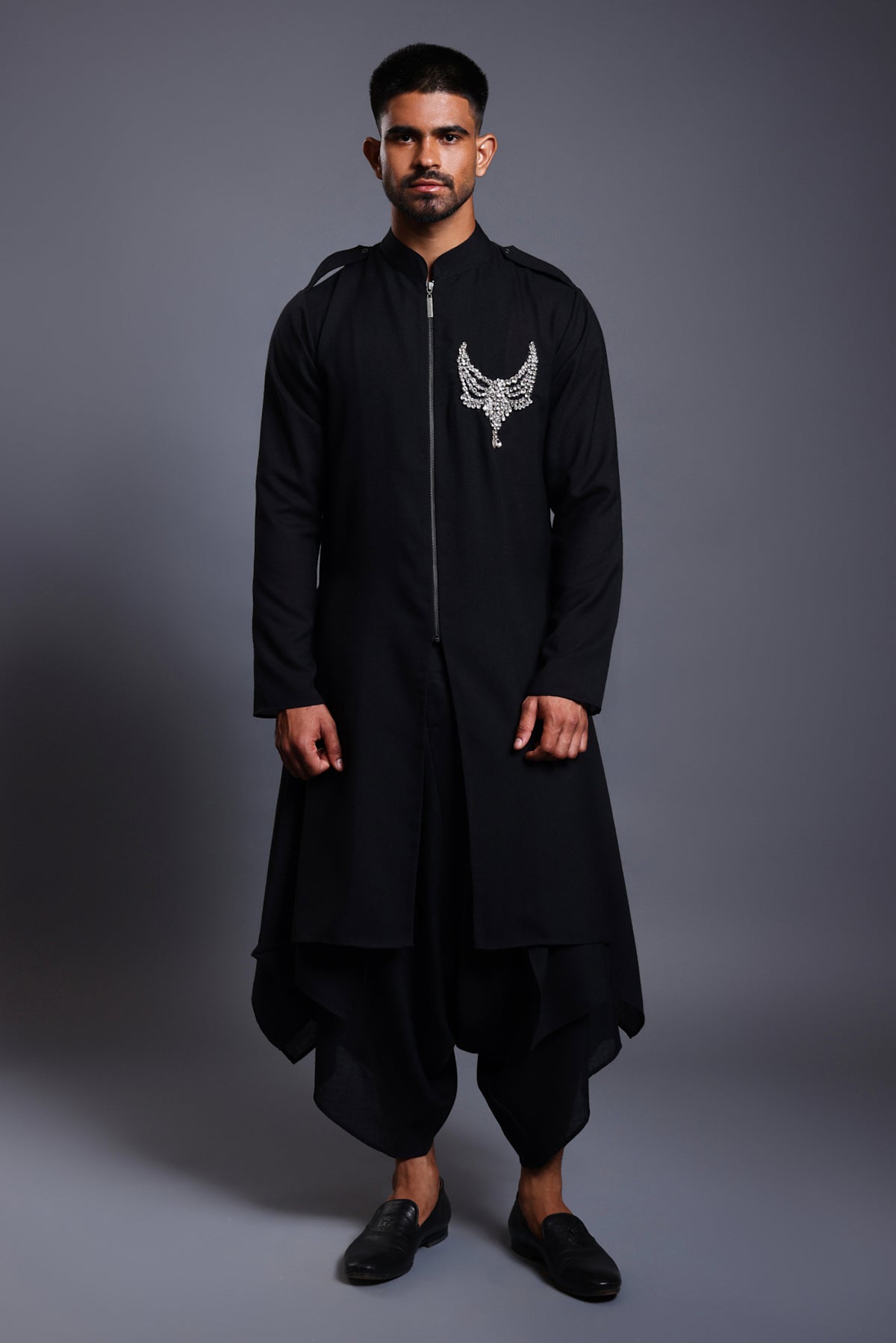 Close-up of black linen kurta with an intricately designed crystal necklace crest.