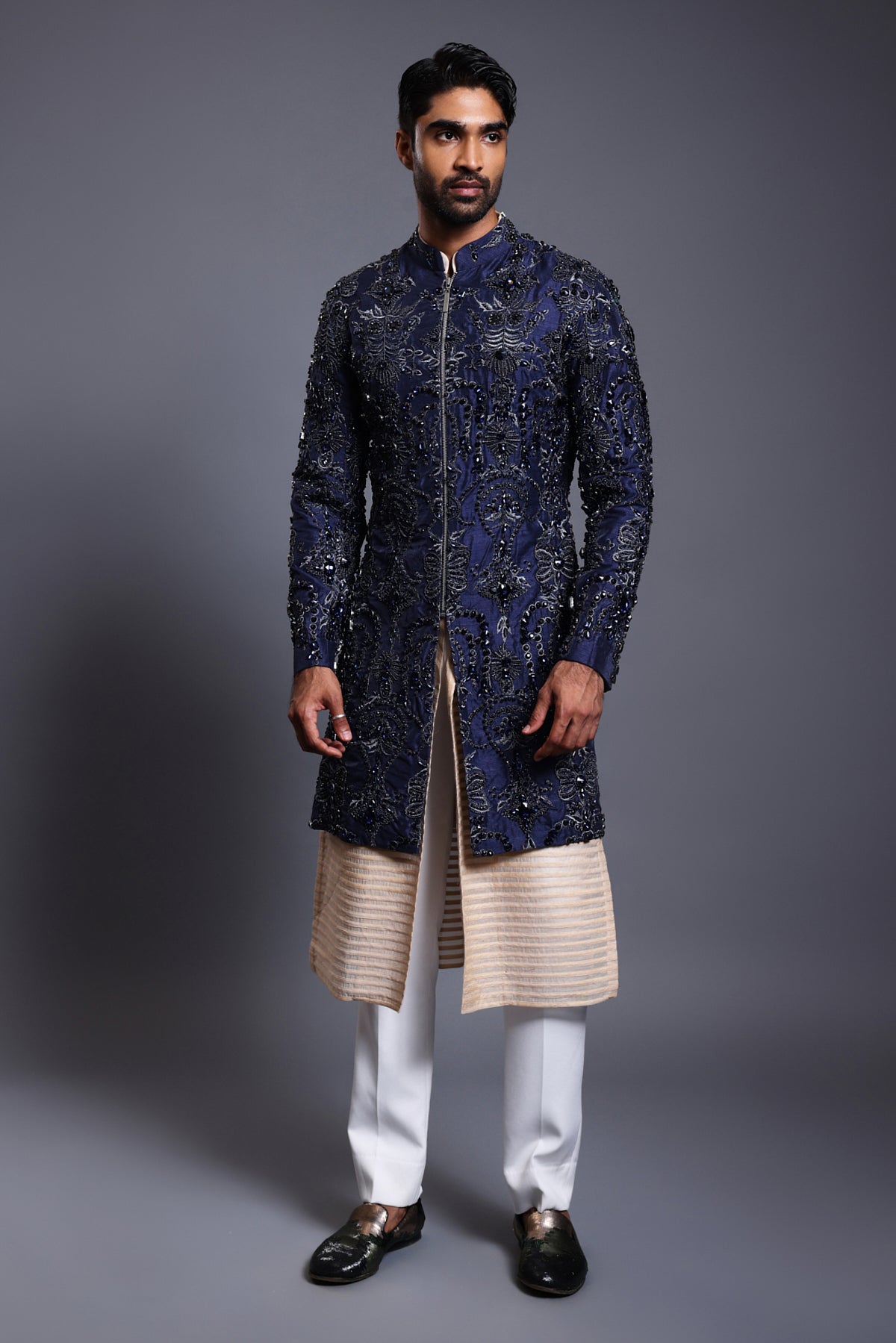 Navy silk sherwani with crystal, beads, and zircon embroidery, paired with a stripwork sherwani kurta for a luxurious and modern look.