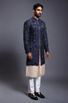 Elegant navy silk sherwani adorned with intricate crystal, beads, and zircon embroidery, complemented by a stripwork kurta