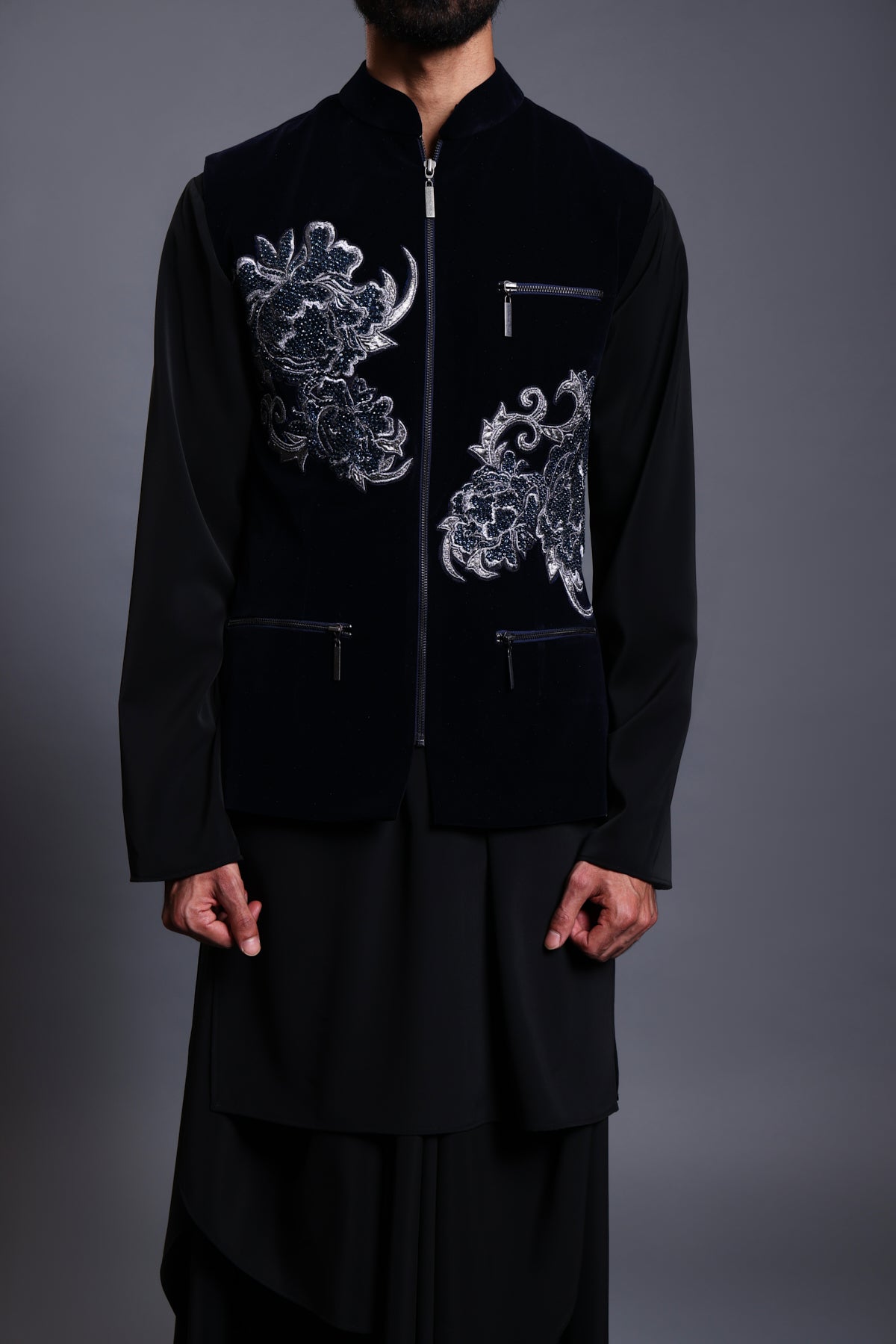 Elegant navy velvet waistcoat adorned with crystal and zari flowers, complemented by a matching kurta and modern draped pants