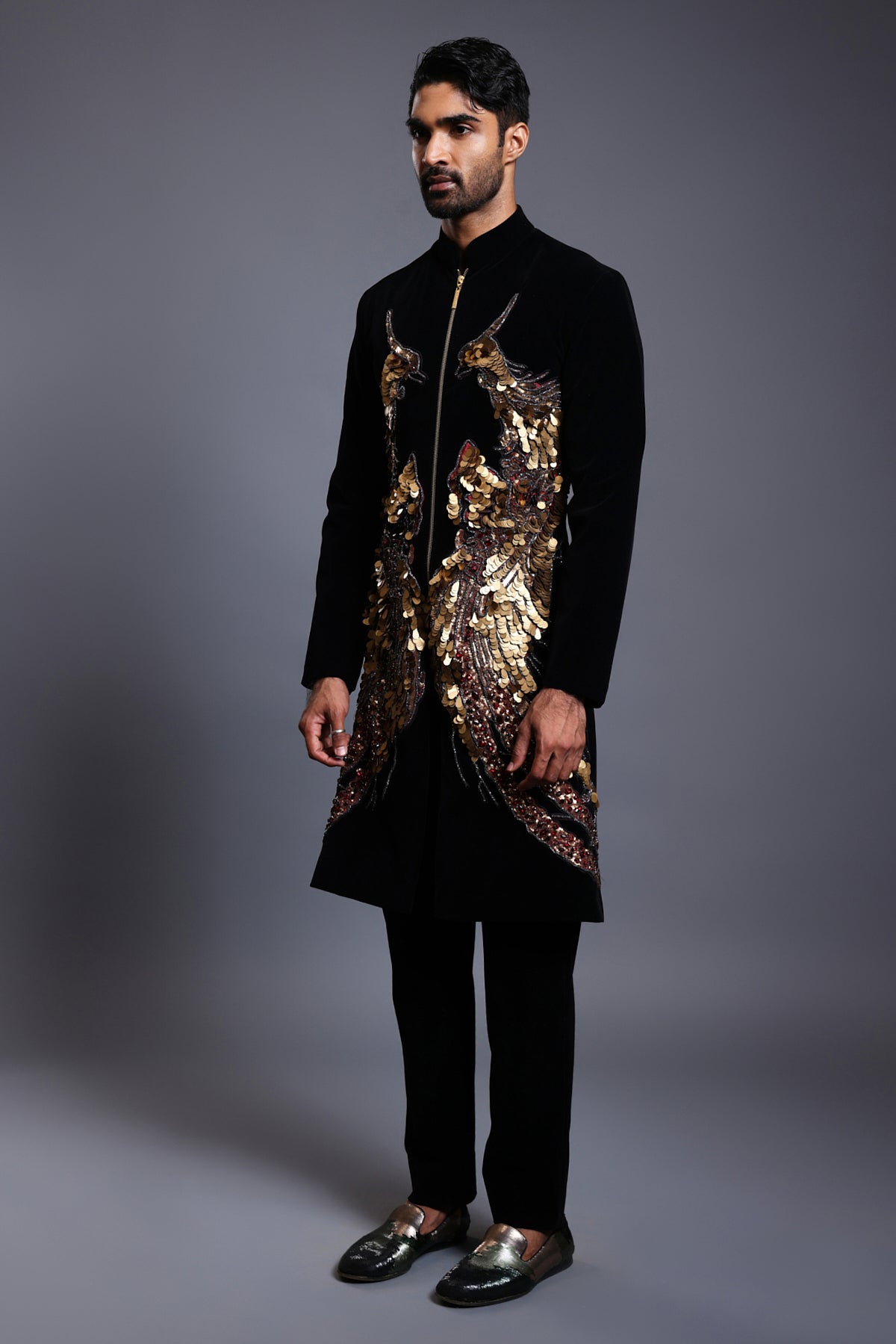 Close-up of a black velvet sherwani featuring detailed phoenix bird embroidery in various textures and techniques.