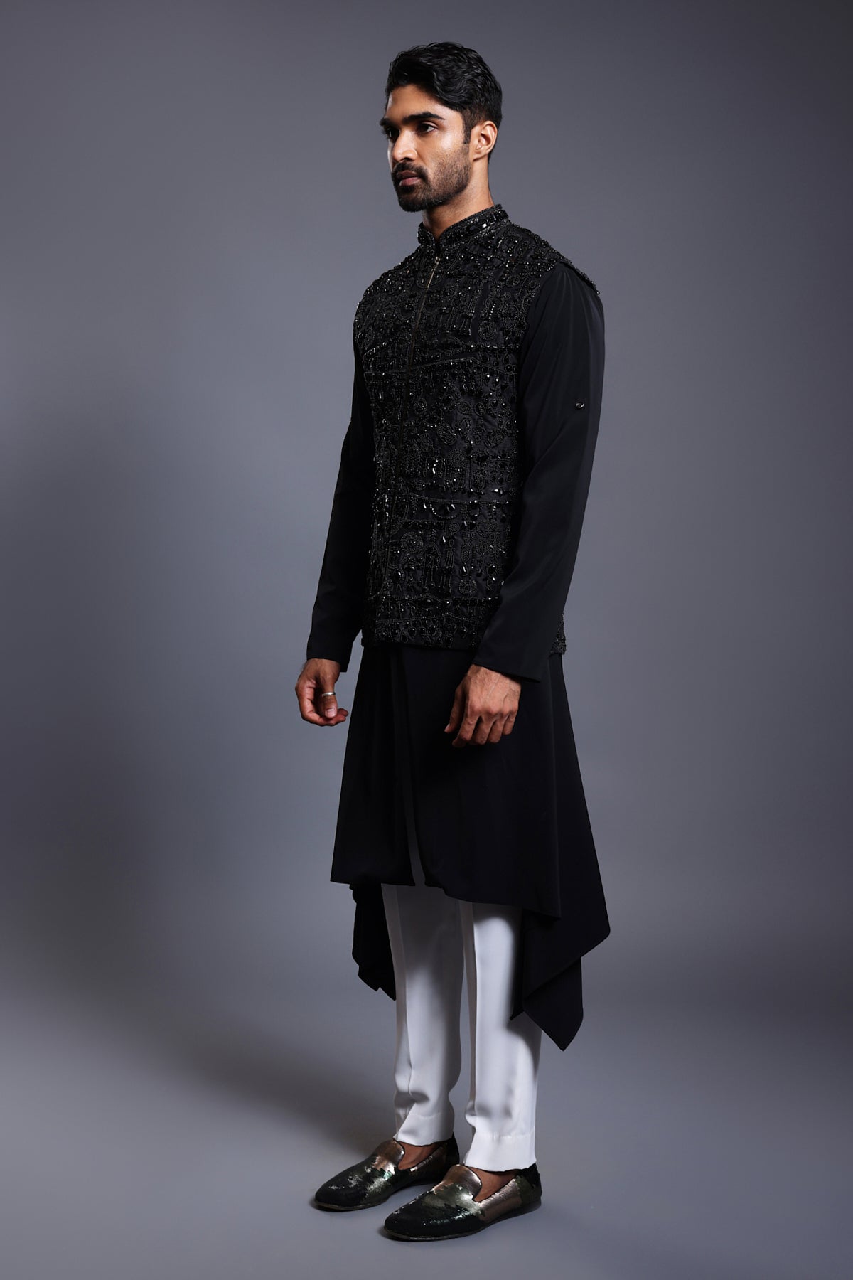 Elegant black silk waistcoat featuring detailed crystal, bead, and zircon embroidery, matched with a draped kurta set for a refined appearance