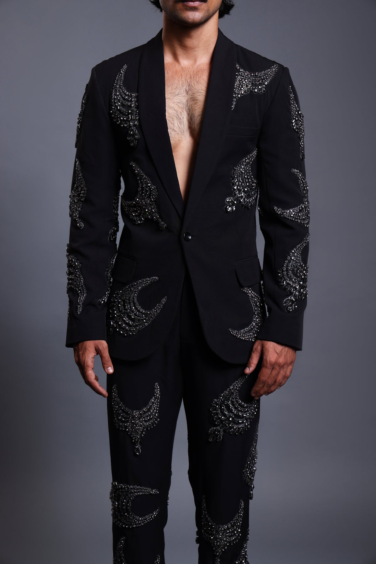 Black knit suit adorned with sparkling crystal necklace crests, ideal for formal occasions.