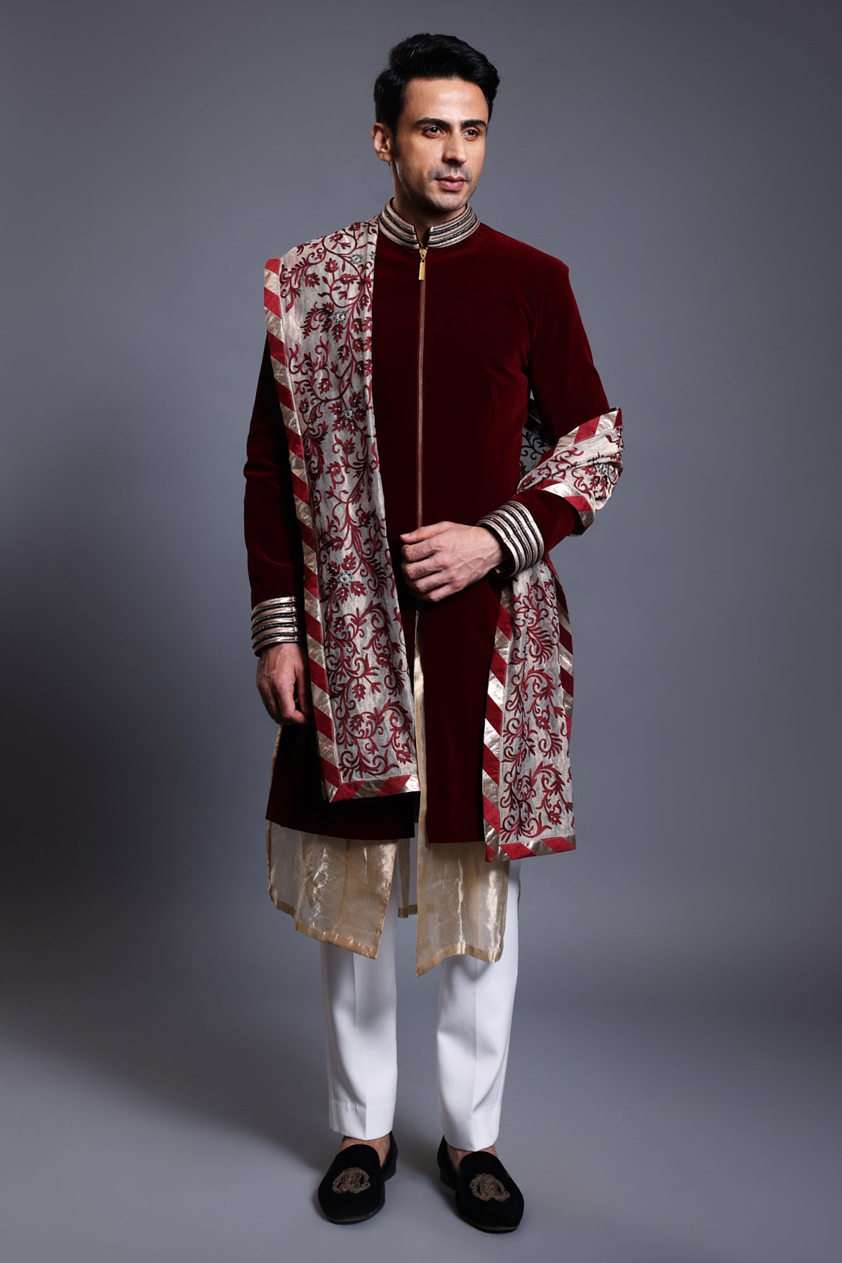 Maroon velvet sherwani with intricate crystal ropework, paired with a thread and crystal dupatta and a tissue kurta