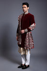 Close-up of maroon velvet sherwani showcasing detailed crystal ropework, complemented by a thread and crystal dupatta