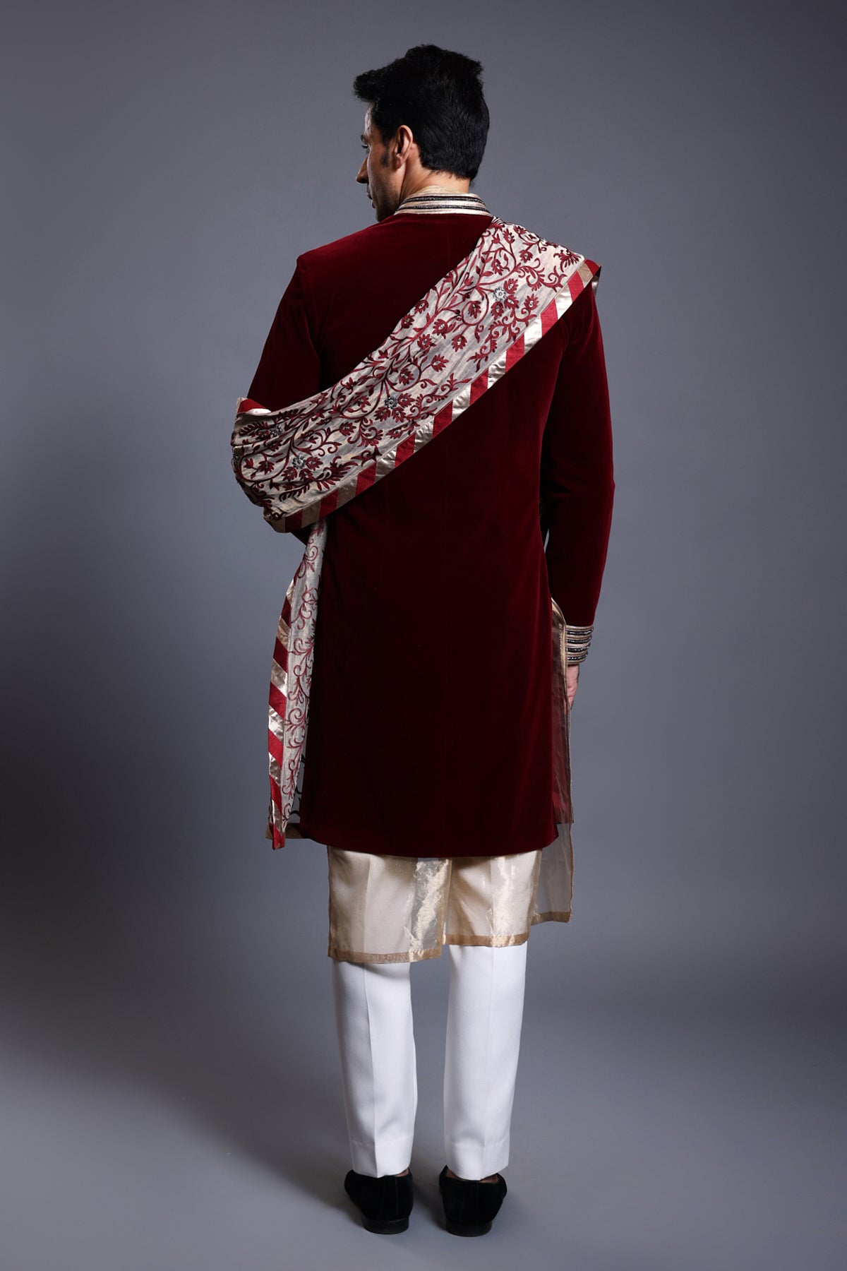 Elegant maroon velvet sherwani with shimmering crystal accents, featuring a matching thread and crystal dupatta and a tissue kurta