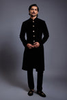 Close-up of emerald velvet sherwani featuring gleaming gold buttons for a regal look