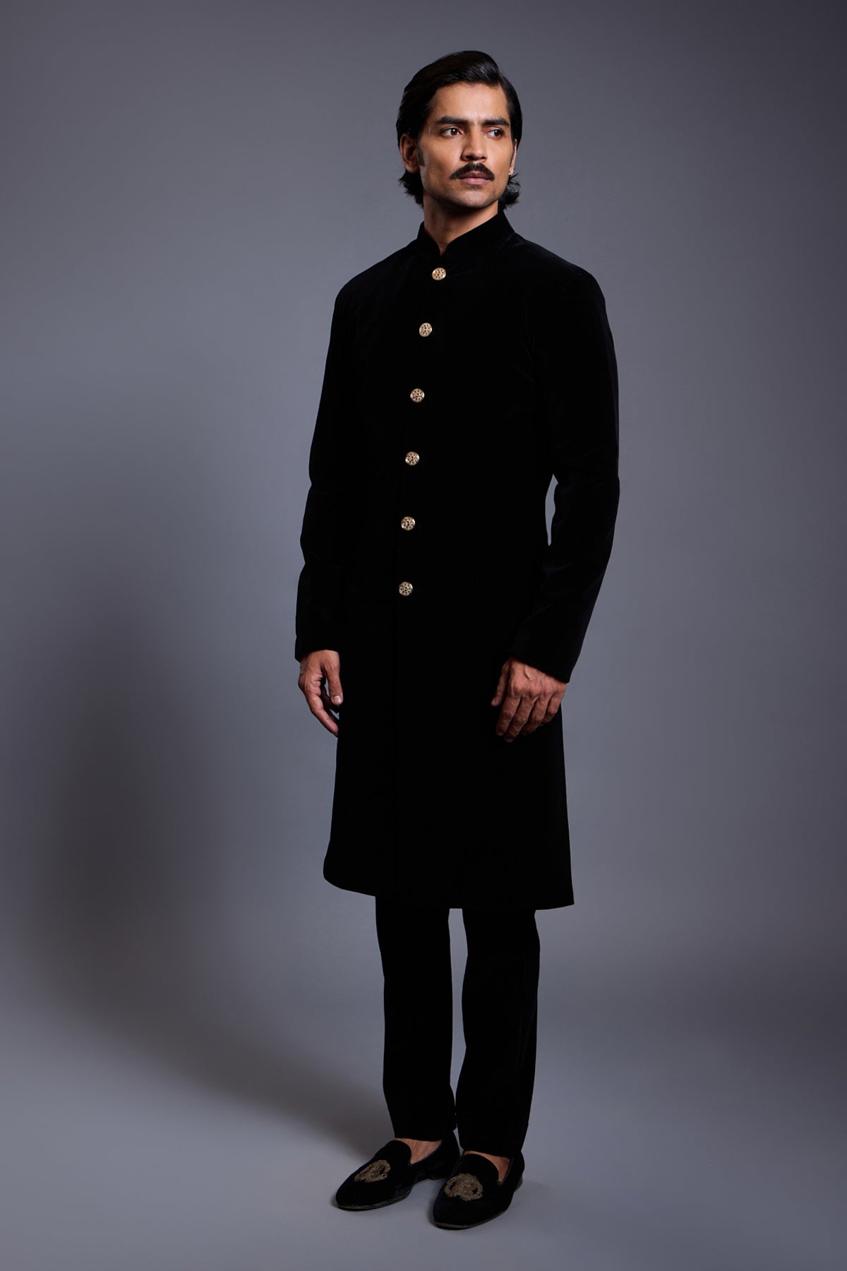 Luxurious emerald velvet sherwani with gold buttons, perfect for formal occasions and weddings.