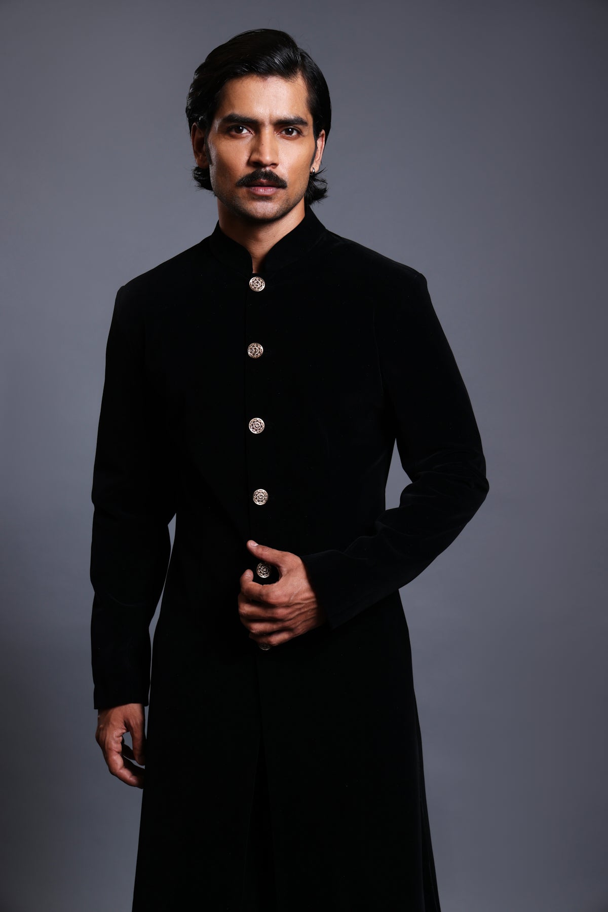 Emerald velvet sherwani with gold buttons, showcasing classic elegance and luxury