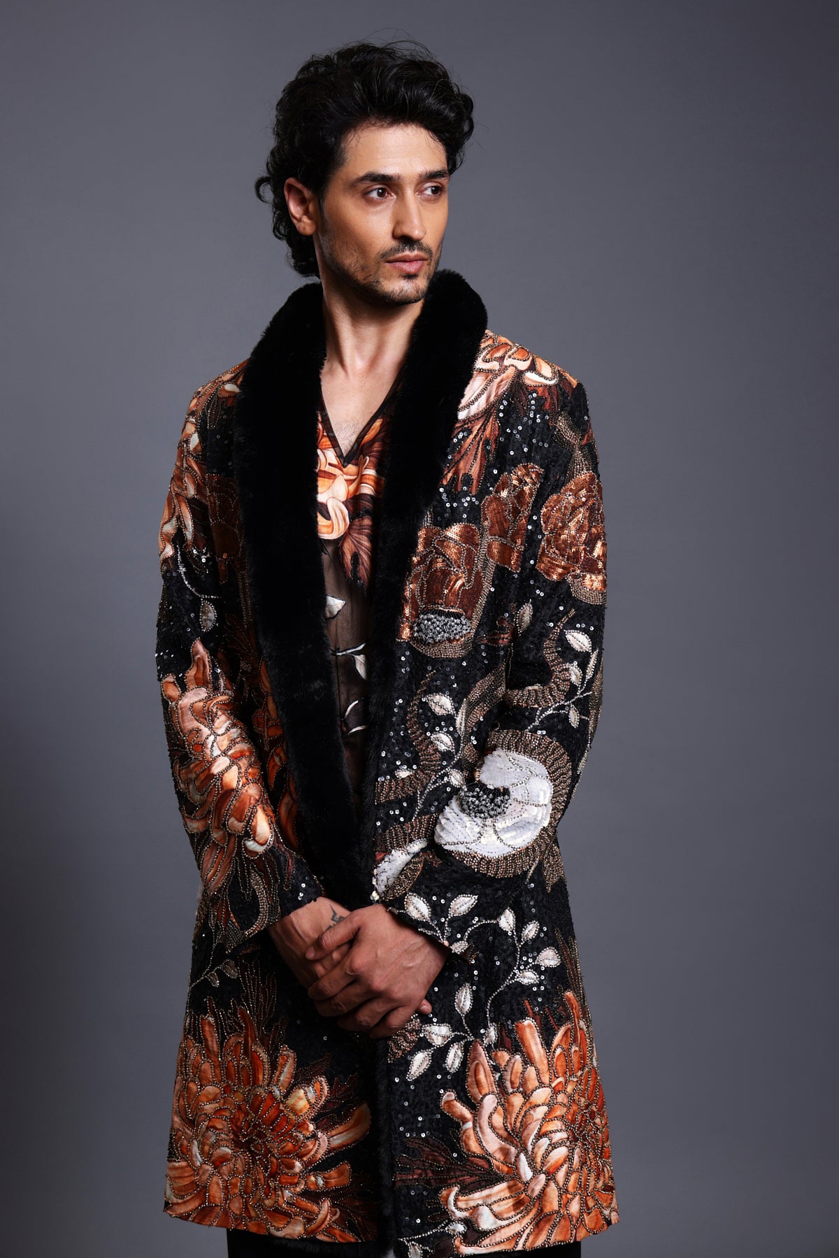 Close-up of black snake printed overcoat with intricate mixed media embroidery and a luxurious faux fur collar.