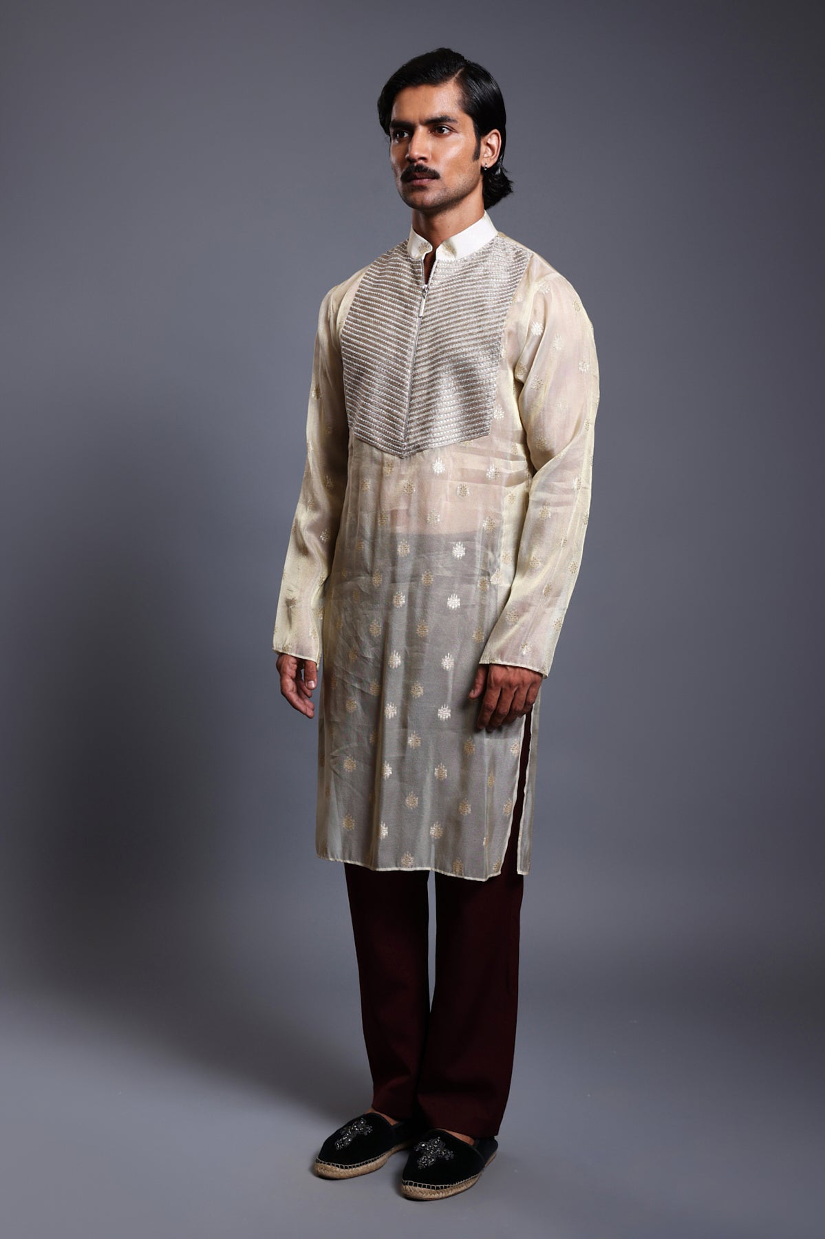 Close-up of ivory chanderi kurta with intricate gold zari work and sparkling crystal yoke