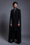 Close-up of black overcoat with fluid draped sleeves and an elegant cape