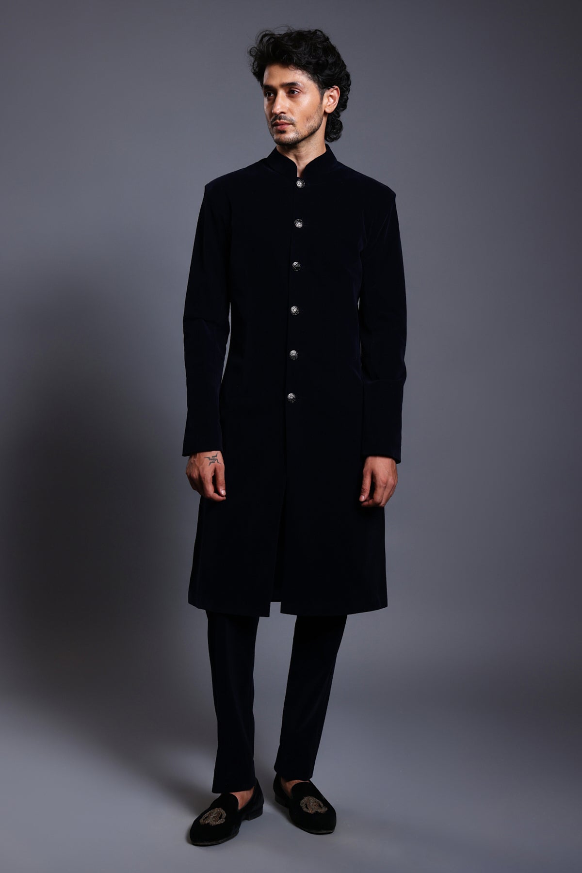 Classic black velvet sherwani with stylish gunmetal buttons, combining traditional elegance with modern refinement.