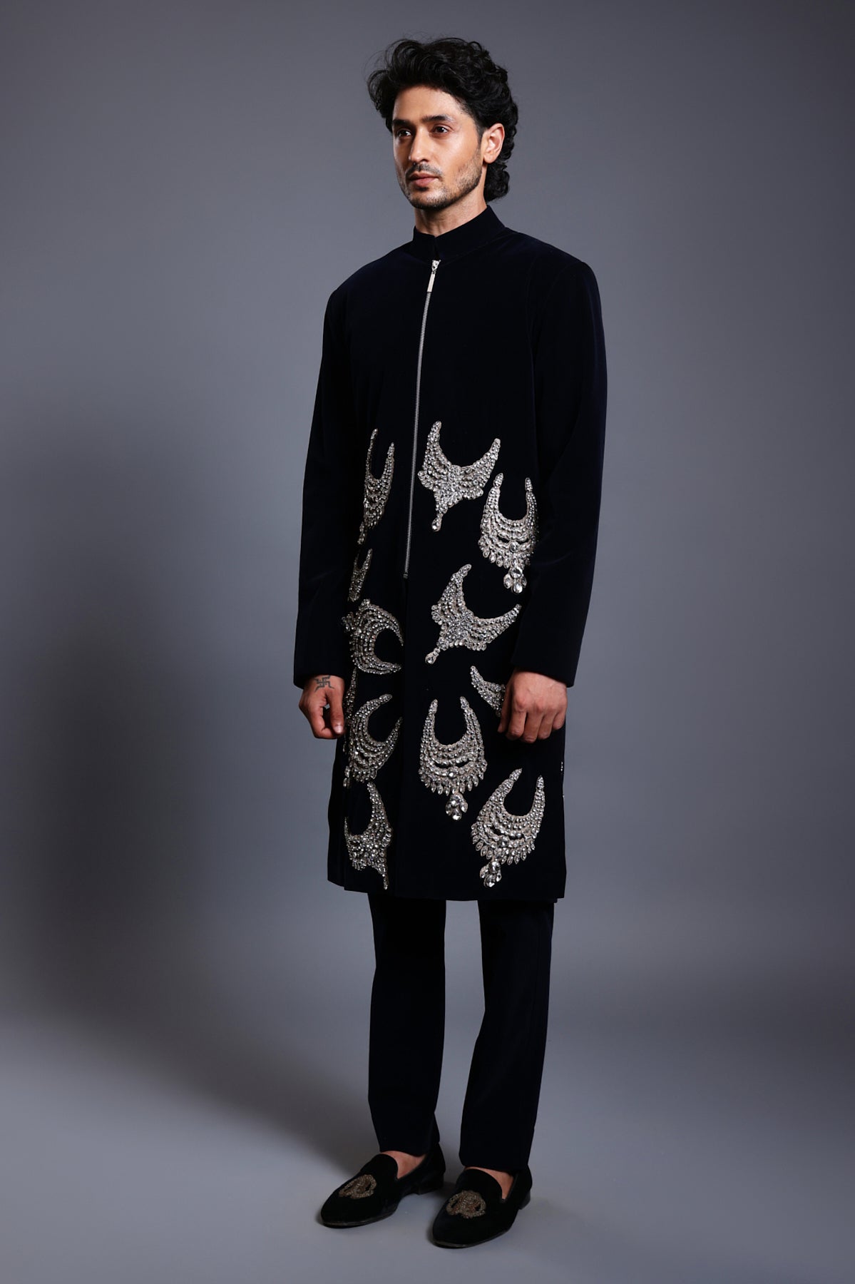 Navy velvet sherwani featuring intricate patchwork necklaces, combining luxury with traditional elegance.