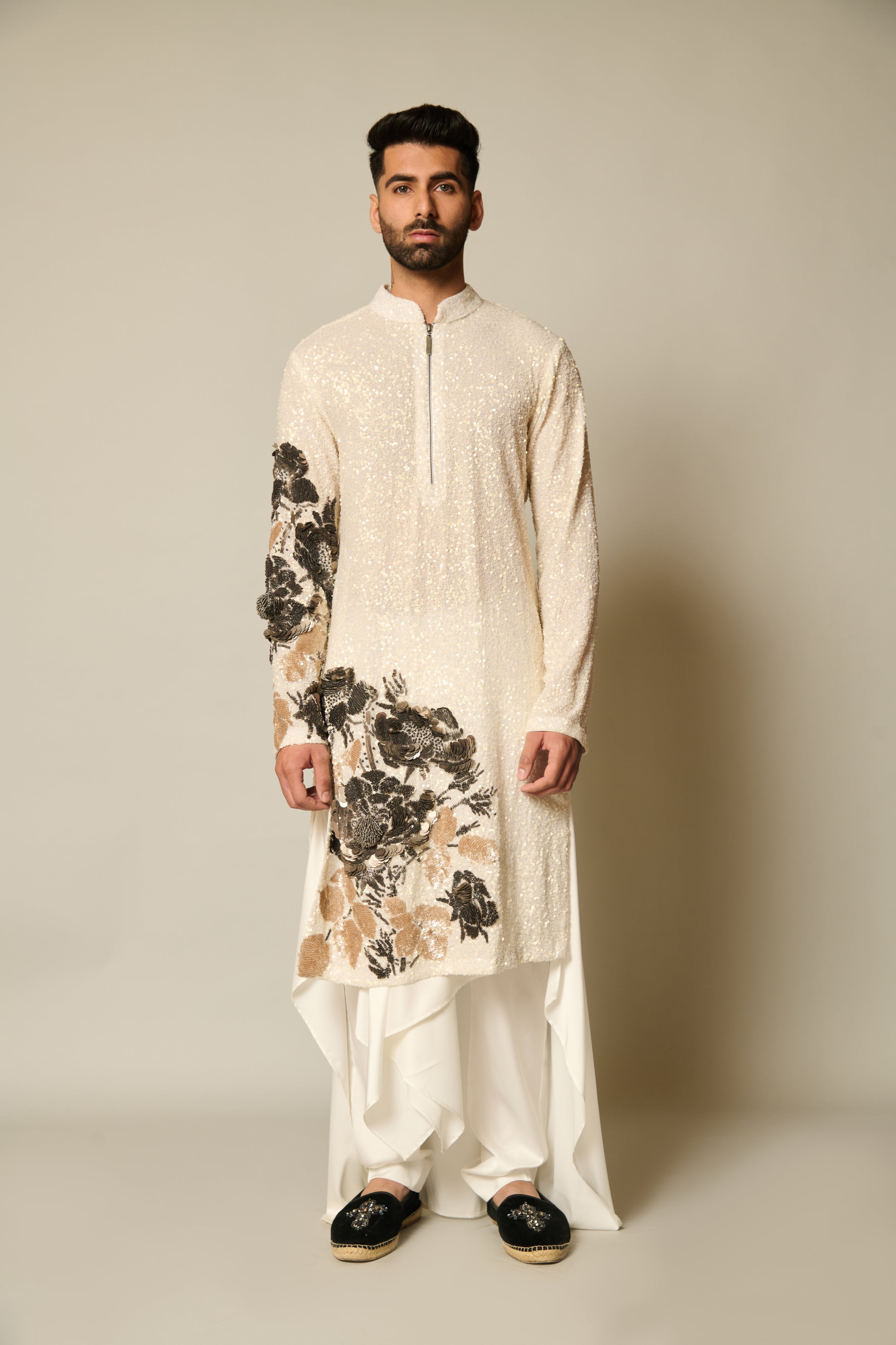 Sophisticated ivory sequin-embroidered kurta with metallic 3D floral accents, matched with ivory satin pants and a draped skirt overlay