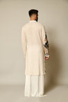 Graceful ivory kurta embellished with sequin and metallic 3D flowers, paired with satin pants and a draped skirt overlay for a refined look