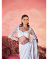 Whispers of Elegance in White: Adorned with exquisite hand-embroidery, this drape saree is a canvas of sophistication. 