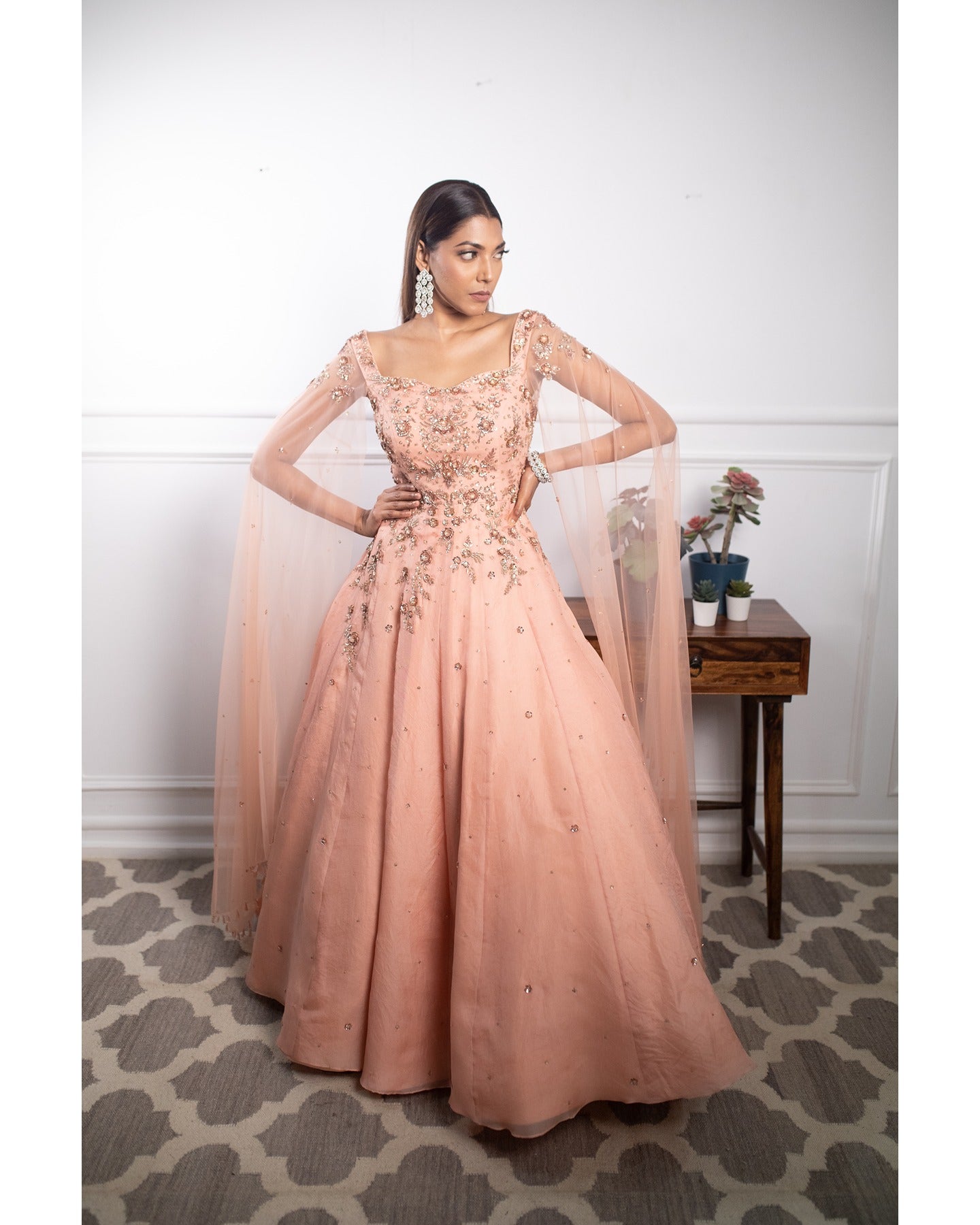 Draped in the soft radiance of peach, this gown whispers elegance and timeless charm.