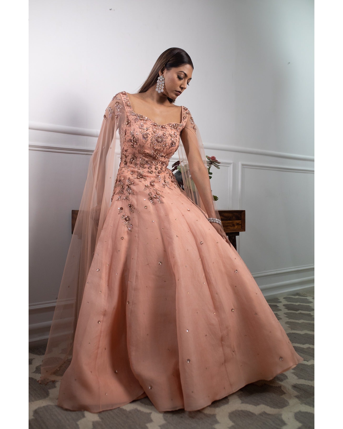 Draped in the soft radiance of peach, this gown whispers elegance and timeless charm.