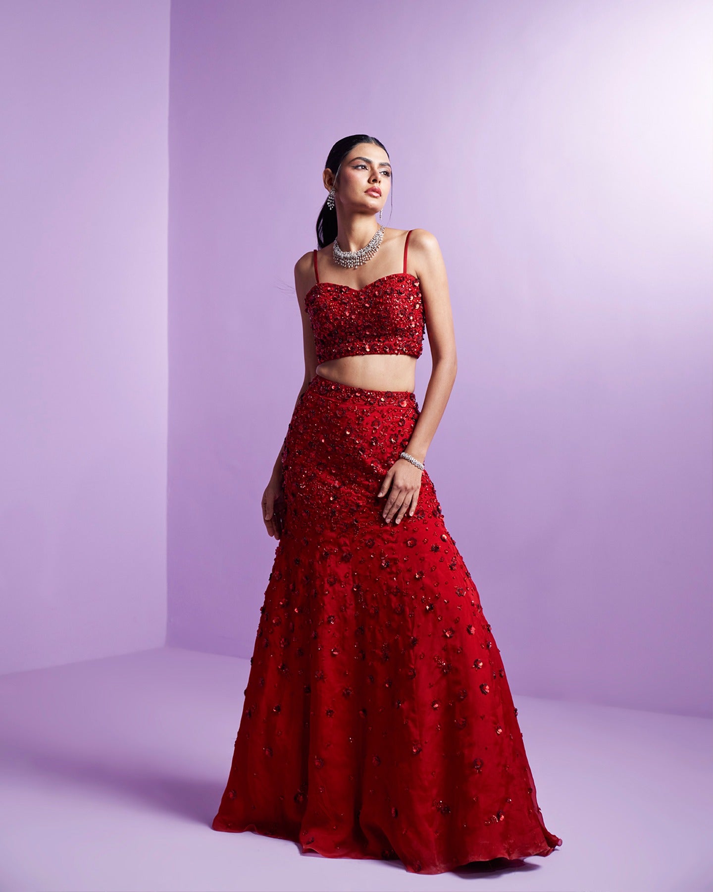 Drenched in passion, this vibrant red lehenga speaks volumes of timeless grace and fiery elegance. A symphony of tradition and modern allure, capturing hearts with every twirl. 