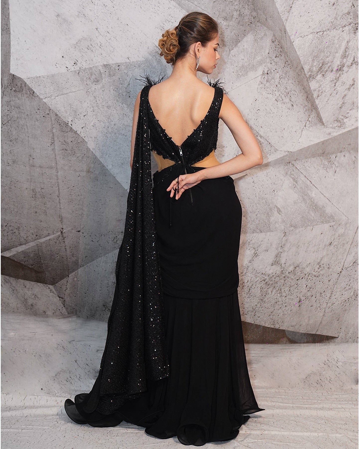 Draped in the mystique of midnight black, this gown is a symphony of sequins, feathers, and intricate embroidery.