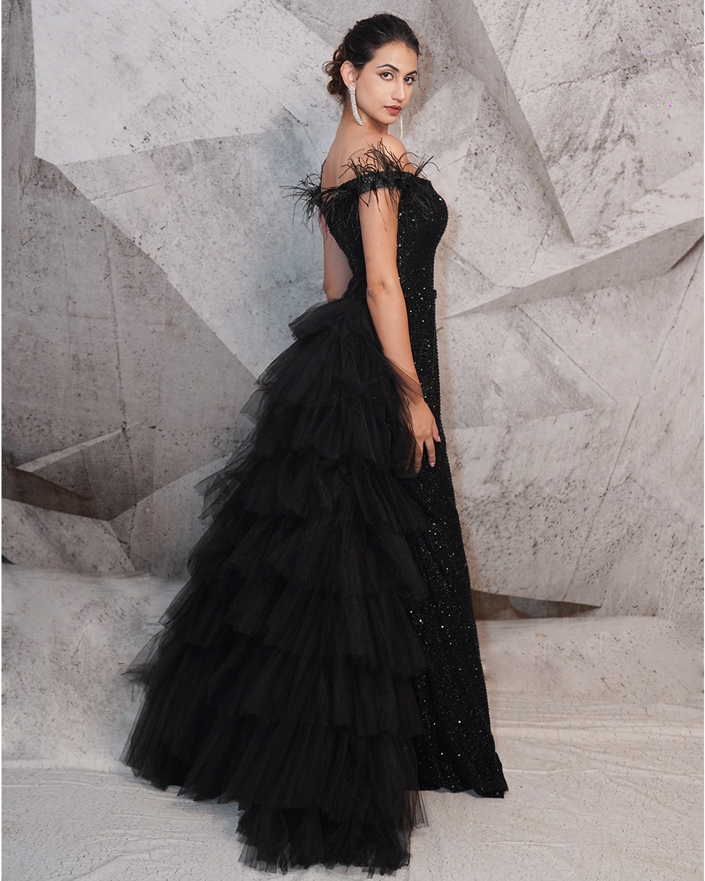 Draped in the mystique of midnight black, this gown is a symphony of sequins, feathers, and intricate embroidery.