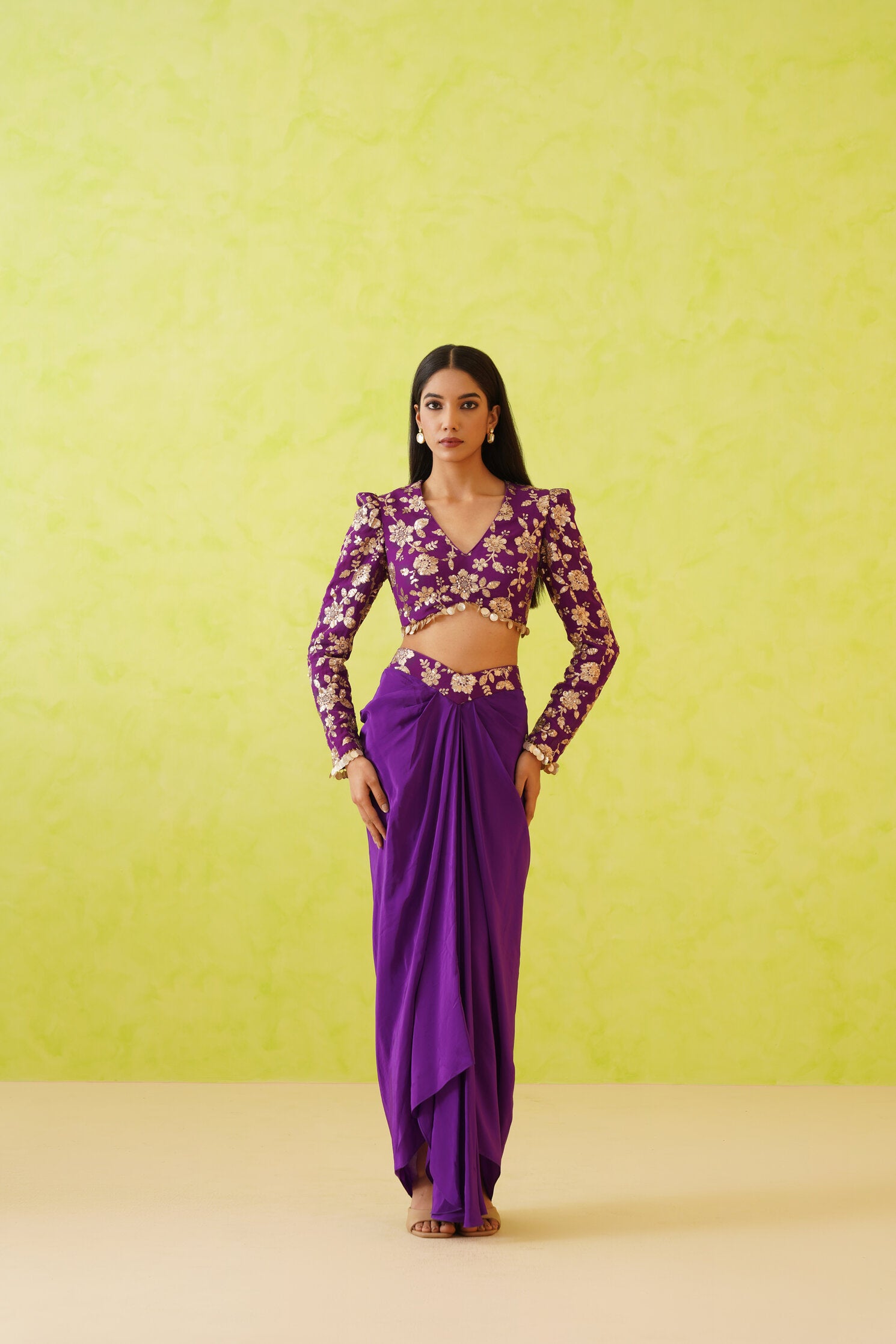 A stunning purple dhoti and blouse set crafted from rich crepe fabric, featuring a flowing silhouette and intricate embellishments, perfect for elevating your festive wardrobe.