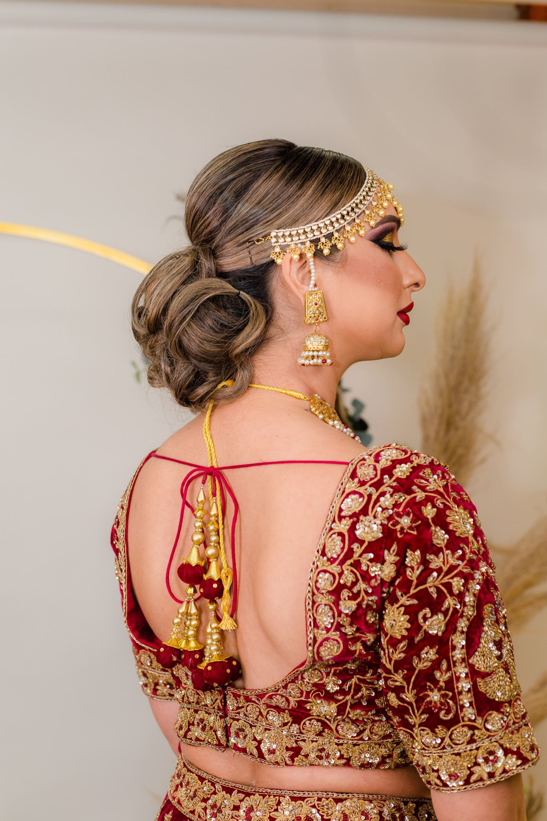 A low bridal bun tucked with Red Roses and baby breaths on a classic red  lehenga can n… | Bridal hair buns, Bridal hair decorations, Bridal  hairstyle indian wedding